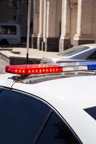 Een politieauto met rode en blauwe sirenes bij de controlepost. Politiewerk. — Stockfoto