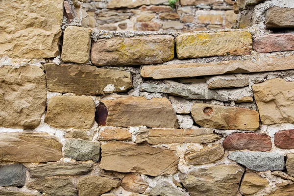 Den grova strukturerade ytan av den vilda stenmuren. Bakgrund. — Stockfoto