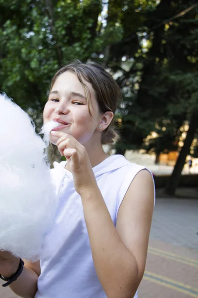 소녀는 놀이공원에서 솜사탕을 먹는다 — 스톡 사진