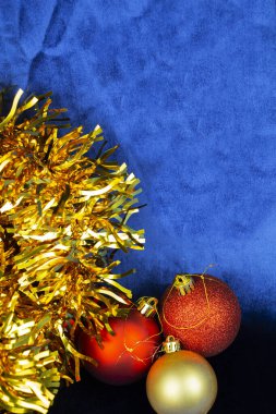 Mavi kadife arka planda balon şeklinde Noel oyuncakları..