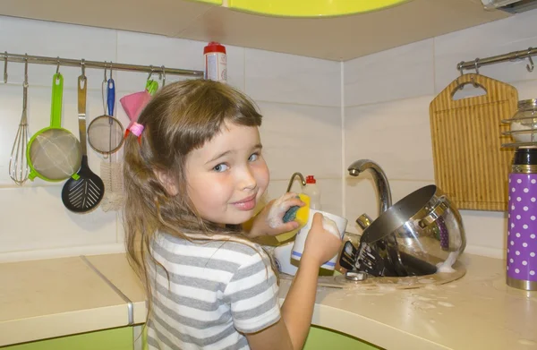 Κοριτσάκι στην κουζίνα πλένει τα πιάτα — Φωτογραφία Αρχείου