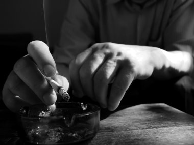 Sigarayı küllüğe koyan el.