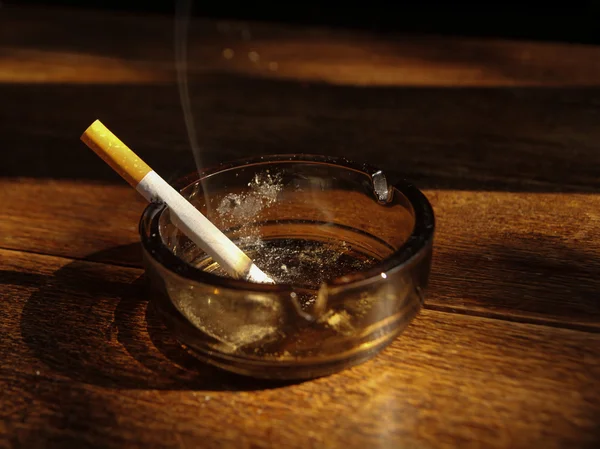 灰皿の上にタバコを置く手 — ストック写真