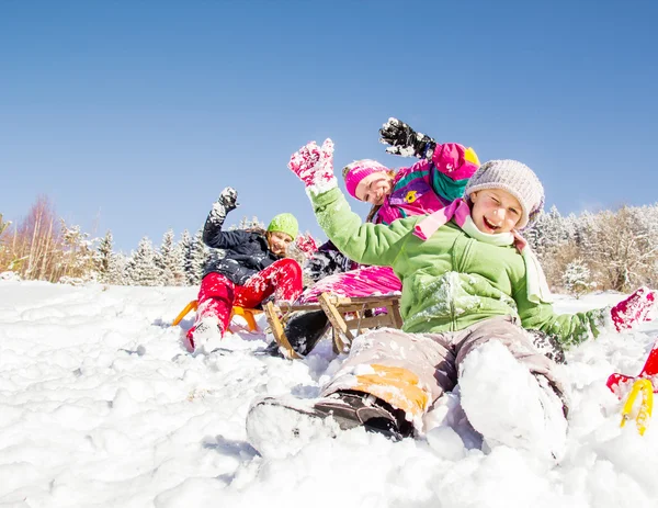 幸せな子供たちは冬に寝ていた 冬に楽しい時間を過ごす子供たちのグループ — ストック写真