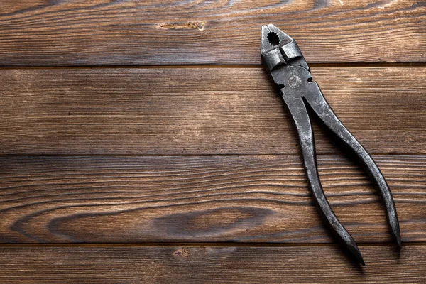 Old rusty pliers on wooden background — Stock Photo, Image