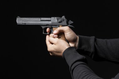 siyah arka plan üzerine izole silah ile erkek el