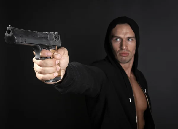 Mann schießt Waffe isoliert auf grauem Hintergrund. Fokus auf Waffe — Stockfoto