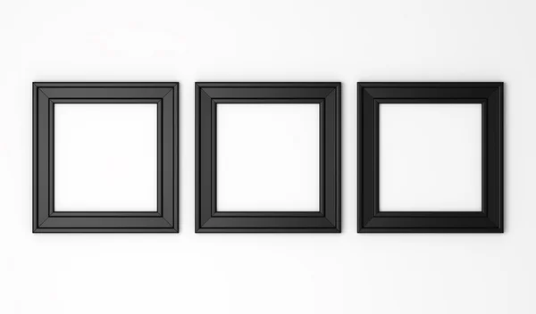 Three blank black photo frames on white wall — Stock Photo, Image