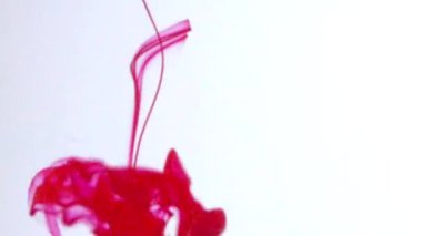 Sudaki kırmızı mürekkep dönüyor, açık arkaplana doğru akıyor..