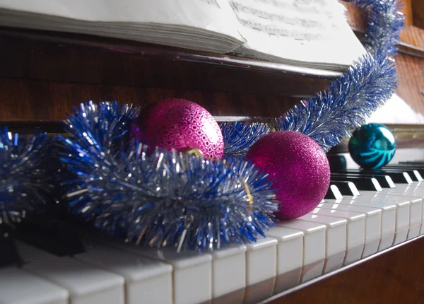 Los atributos de la celebración del Nuevo año y la Navidad se encuentran al piano —  Fotos de Stock