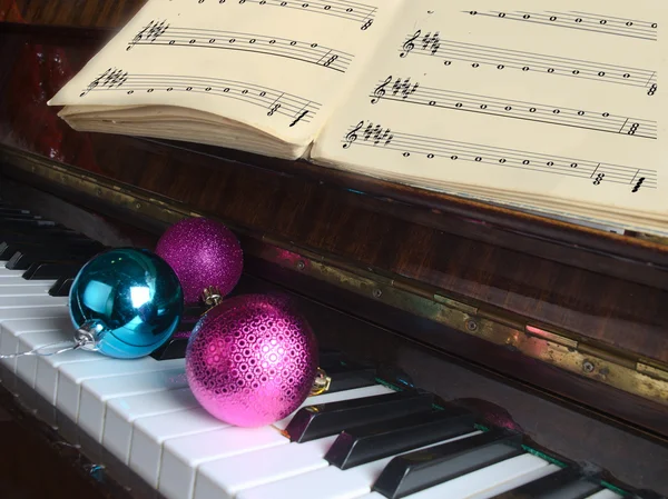 Gli attributi di celebrazione di Anno nuovo e bugia di Natale su un pianoforte — Foto Stock
