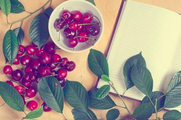 Sweet cherry and notebook for daily records — Stockfoto