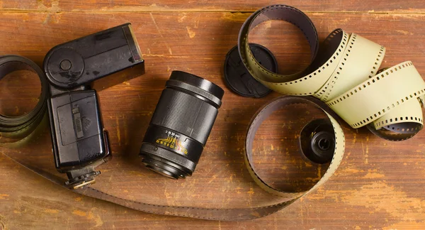 Старая пленка для камеры, объектив и фонарик — стоковое фото