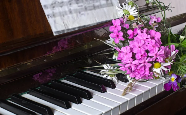 Strauß Sommerblumen auf einem Klavier — Stockfoto