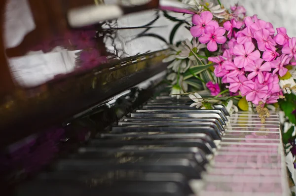 Bukett sommerblomster på et piano – stockfoto