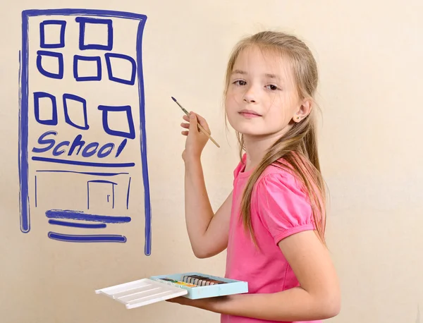 La chica dibuja el edificio de la escuela en una pared — Foto de Stock