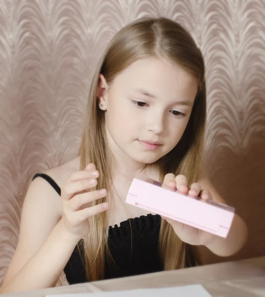 The girl considers a box with children's cosmetics — Stock Photo, Image