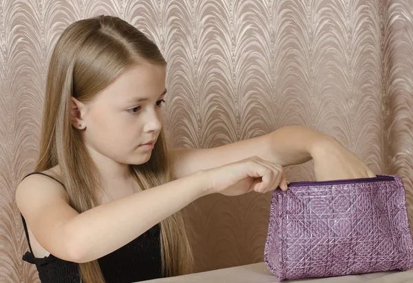 the girl opens a ladies' handbag