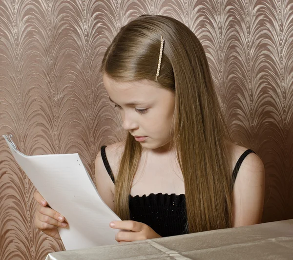 La niña observa las hojas de papel puestas —  Fotos de Stock