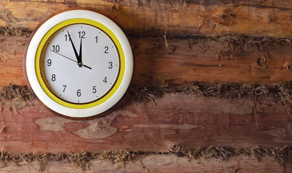 The clock on the old wall made of logs — Stock Photo, Image