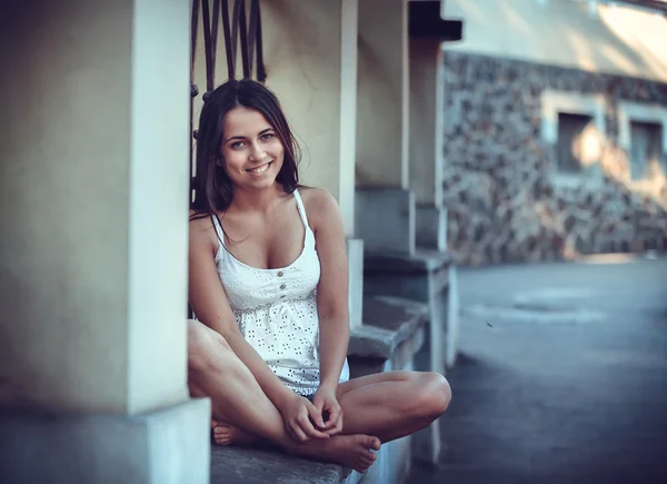 Brunette girl sitting on street — Stock Photo, Image