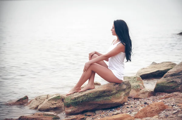 Kobieta na kamienie w pobliżu morza — Zdjęcie stockowe