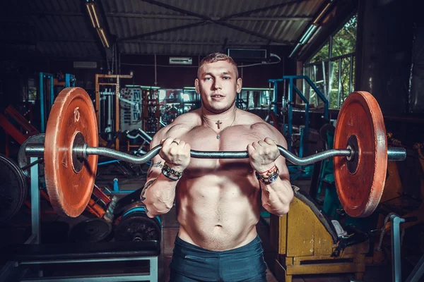 Culturista en sala de entrenamiento — Foto de Stock