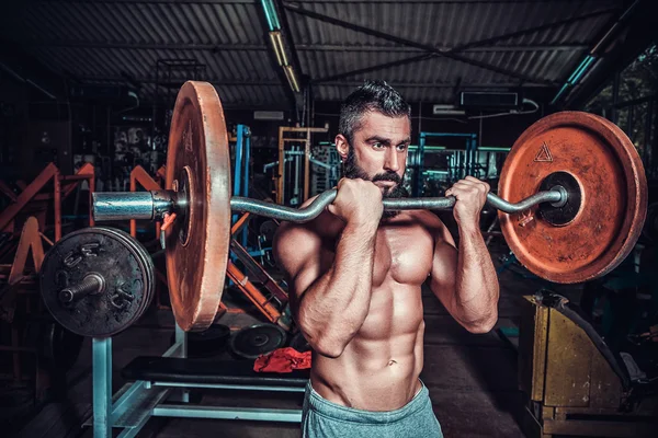 Culturista en sala de entrenamiento — Foto de Stock