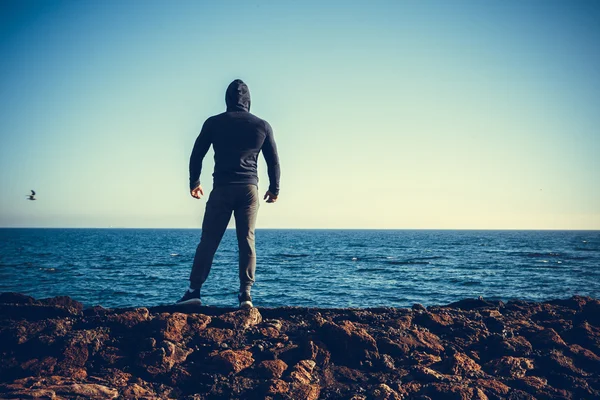 Uomo Atleta in piedi sulla roccia — Foto Stock