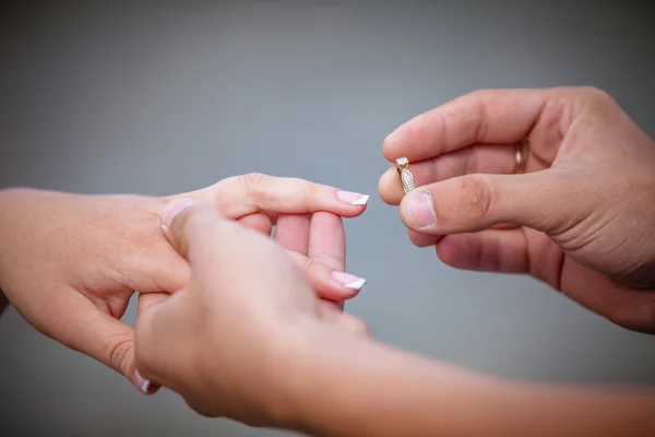 Homme plaçant bague de fiançailles sur doigt — Photo