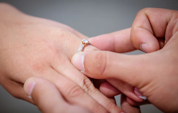 Hombre colocando anillo de compromiso en el dedo — Foto de Stock