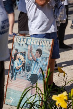 Buenos Aires, Arjantin - 26 Kasım 2020: Fotoğraflar, çizimler, hayranların elinde Diego Maradona 'nın bir portresi olan posterler