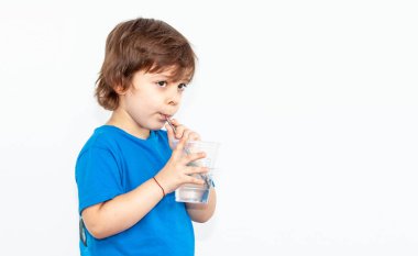 Hafif arka planda bir bardak su olan bir çocuğun portresi.