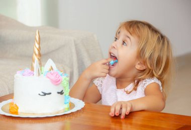 Doğum gününde elinde tek boynuzlu at olan tatlı bir kız.