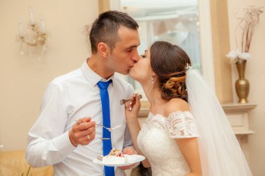 Gelin ve damat düğün pastası yiyorlar.