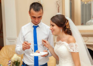 Gelin ve damat düğün pastası yiyorlar.