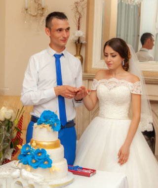 Gelin ve damat düğün pastası yiyorlar.