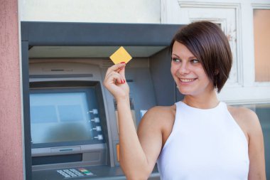 ATM 'de kredi kartından para çeken bir kadın.