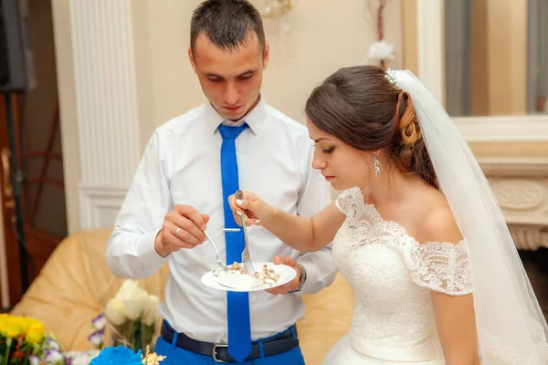 Gelin ve damat düğün pastası yiyorlar.