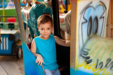 Parktaki atlıkarıncada küçük mutlu bir çocuk.