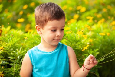 Parkta çiçekli küçük bir çocuk