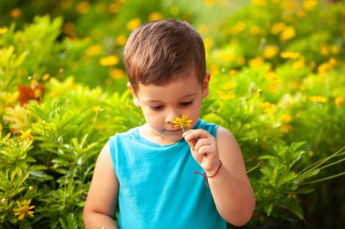 Parkta çiçekli küçük bir çocuk