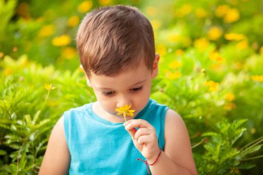 Parkta çiçekli küçük bir çocuk