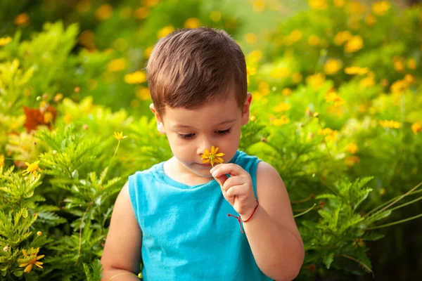 Parkta çiçekli küçük bir çocuk