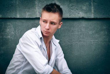 Sokakta oturan genç adam.