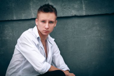 Sokakta oturan genç adam.