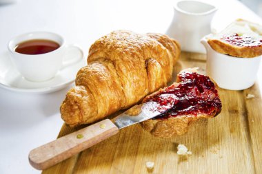 Kahvaltı beyaz bir masada, kruvasan, tereyağı, reçel