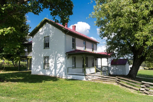 traditional American two-story house of the 18th century with a tree in the yard