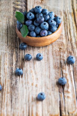 Yaban mersinleri sepetin içinde, ahşap masanın üzerinde.