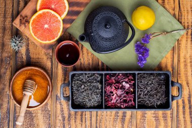 kırmızı, siyah ve yeşil çay, ahşap fincanlarda ve gri arka planda çaydanlık